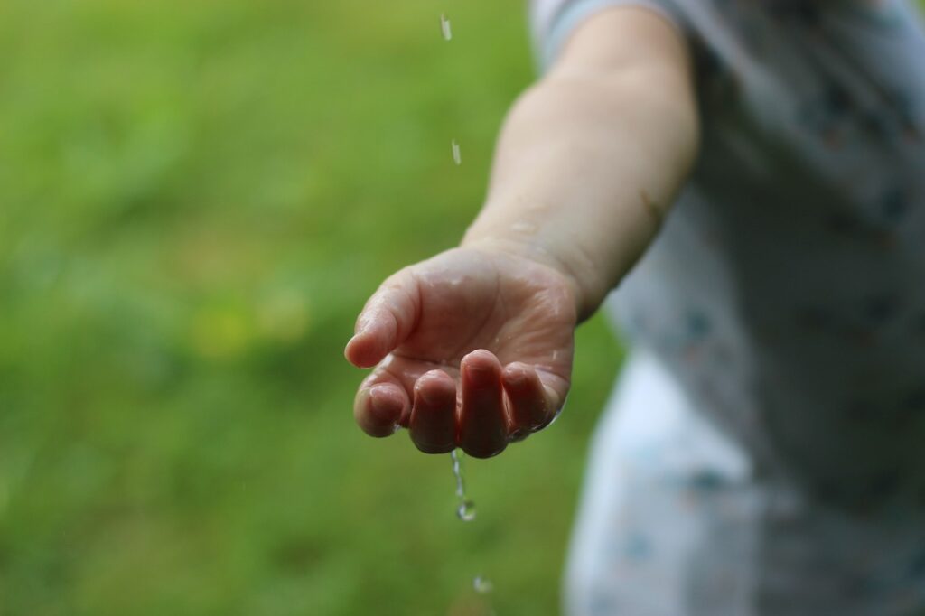 Wasser rieselt durch eine Hand, Bild von Thaliesin from Pixabay
